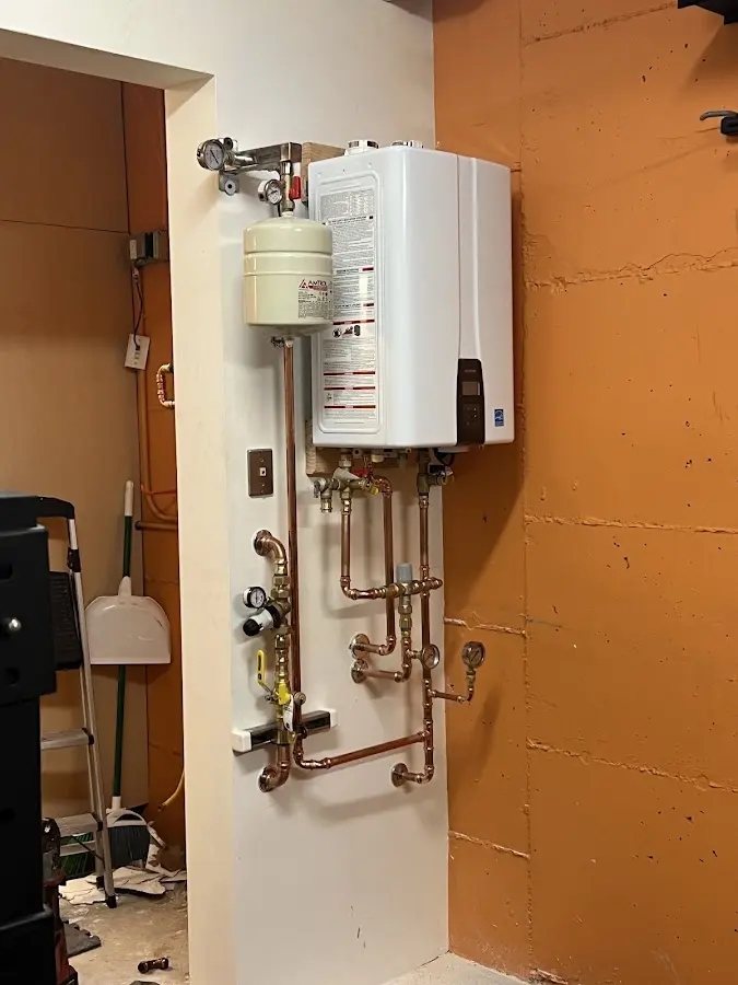 Plumbing technician inspecting water heater connections in Newberg